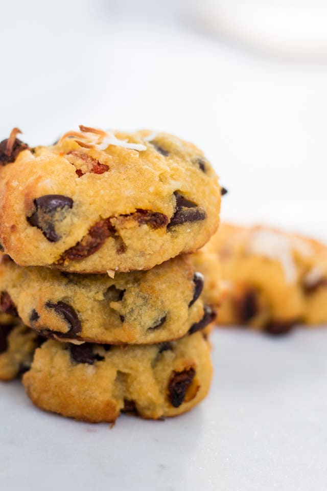 3 coconut flour cookies stacked one on top of the other with a cookie in the background