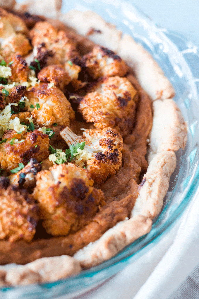 Crispy roasted cauliflower sits a atop a creamy tahini and cauliflower puree with just a hint of lemon.  Perfect picnic food or as a main course paired with a dark leafy salad. #cauliflower #cauliflowerrecipe #tart