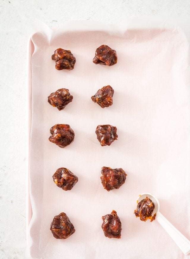 Date caramel balls rolled and placed on parchment paper