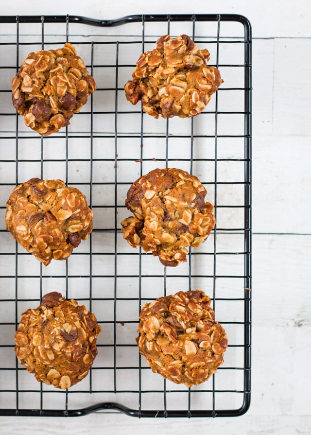 6 freshly baked oatmeal cookies on a black wire cooling rack