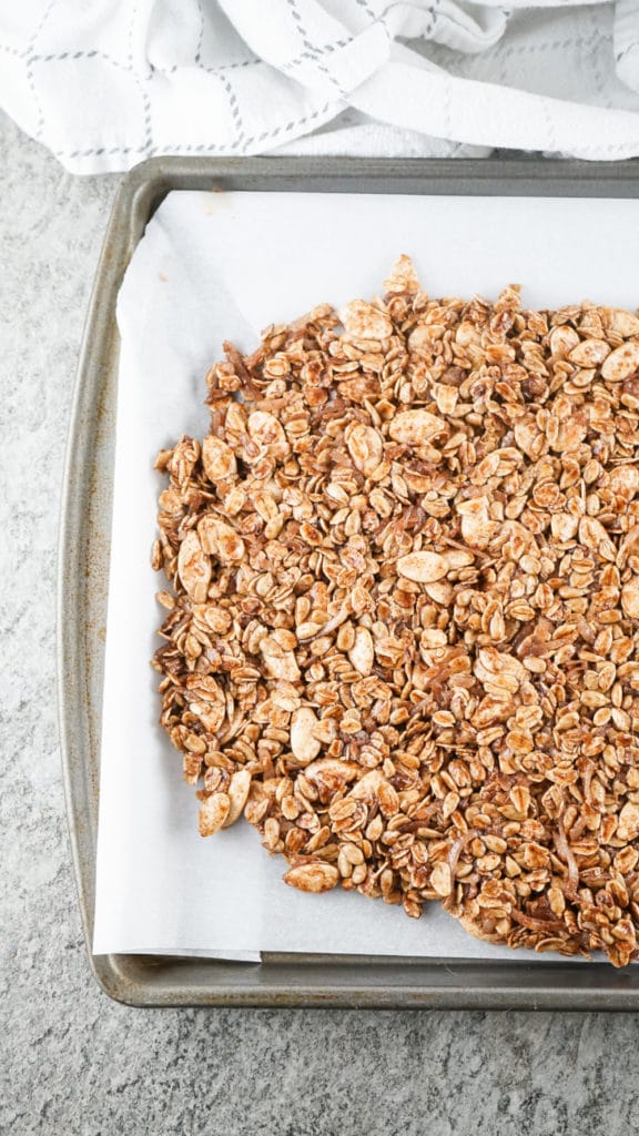 uncooked granola on a baking tray lined with parchment paper