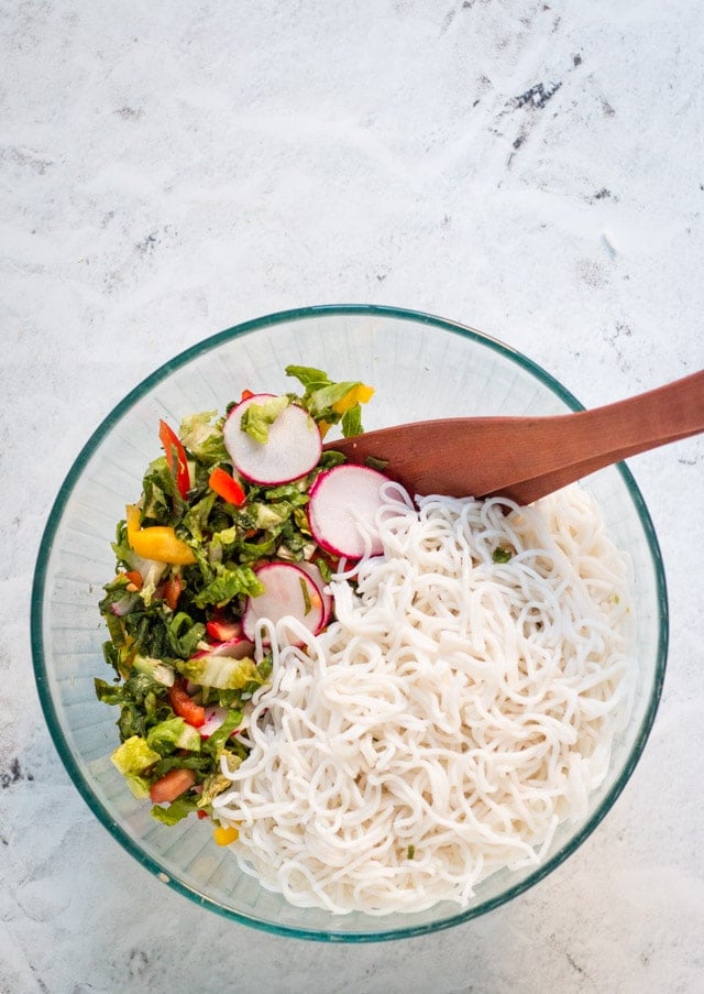 Vegetables and rice noodles in a large glass bowl