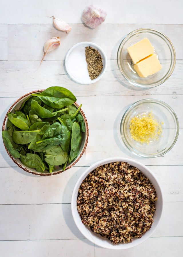 Overhead shot of ingredients required for a garlic spinach and quinoa bowl. Each ingredient is served in a small bowl