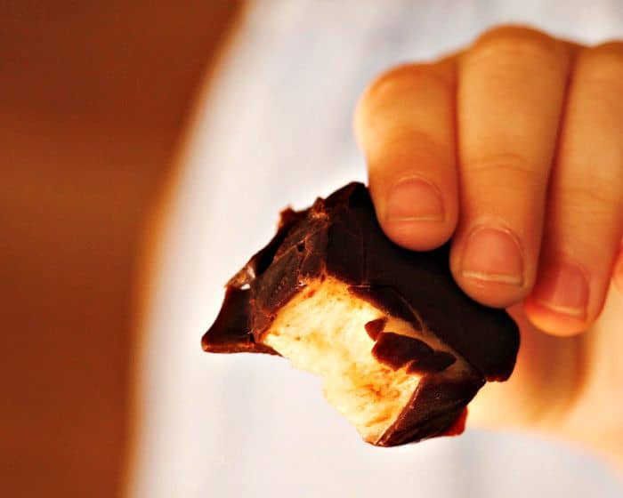 childs hand holding chocolate covered banana bites