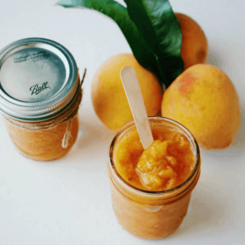 3 ingredient peach butter served in a son jar with 3 fresh peaches behind