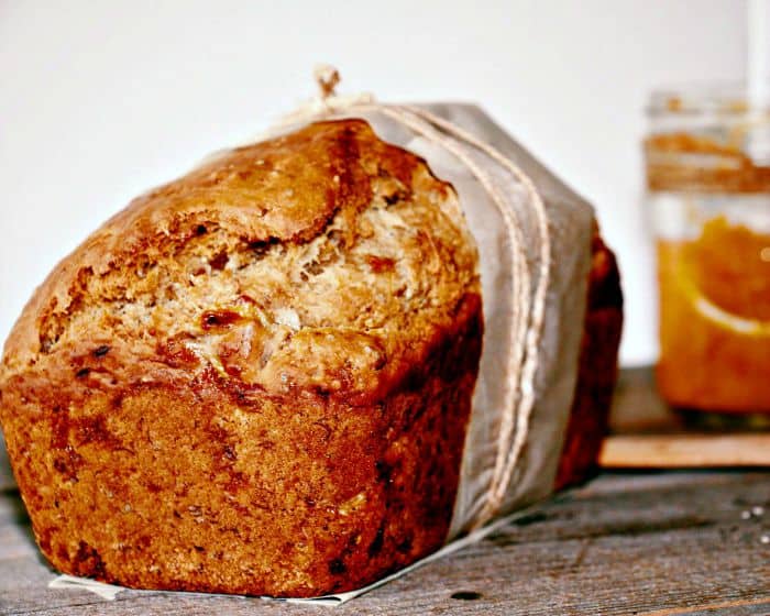 Front view of banana and peach butter bread with a jar of peach butter in the back