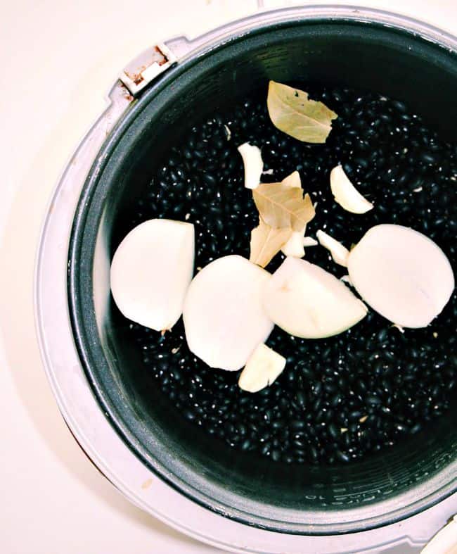 ingredients for slow cooker black beans all added to the bowl of a slow cooker