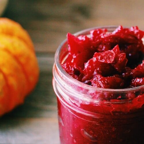 Close up shot of Honey Sweetened Vanilla and Fresh Cranberry Butter with a small pumpkin in the background