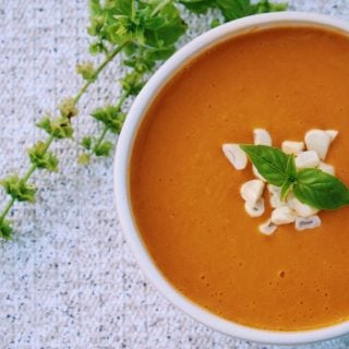 Sweet Potato and Corn Chowder served in a white bowl and topped with some fresh herbs