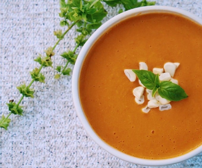 Sweet Potato and Corn Chowder served in a white bowl and topped with some fresh herbs