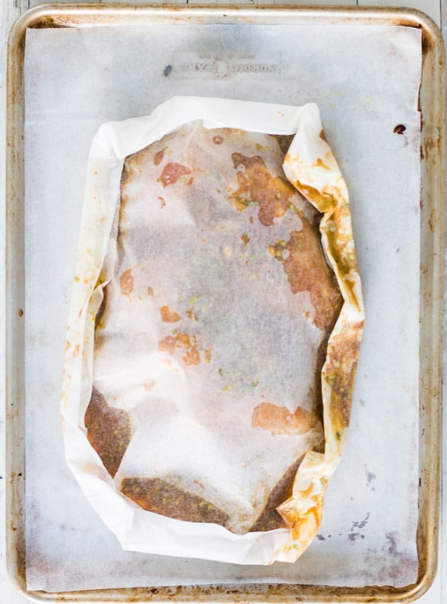 baking sheet with a parchment paper package on top