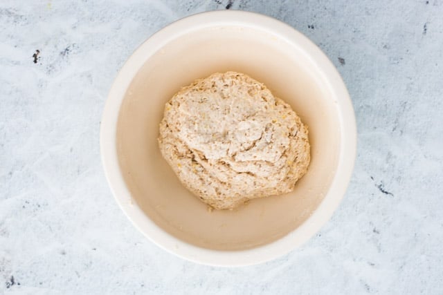 Ingredients for vegan scones combined to a sticky dough in a white bowl