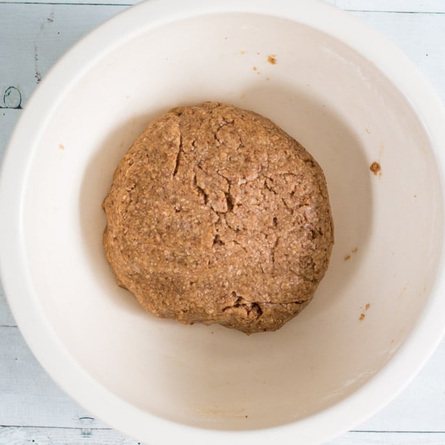 a ball of uncooked graham cracker dough in a white bowl