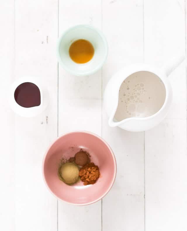 A collection of ingredients required for green tea chai latte displayed in small bowls