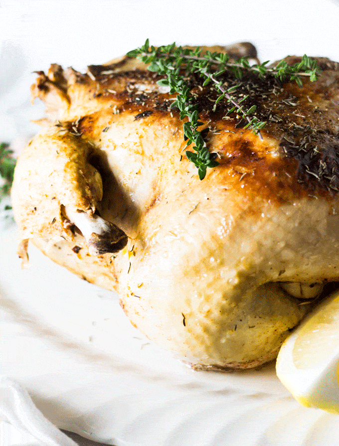 cooked whole chicken with a crispy skin and some fresh thyme on top