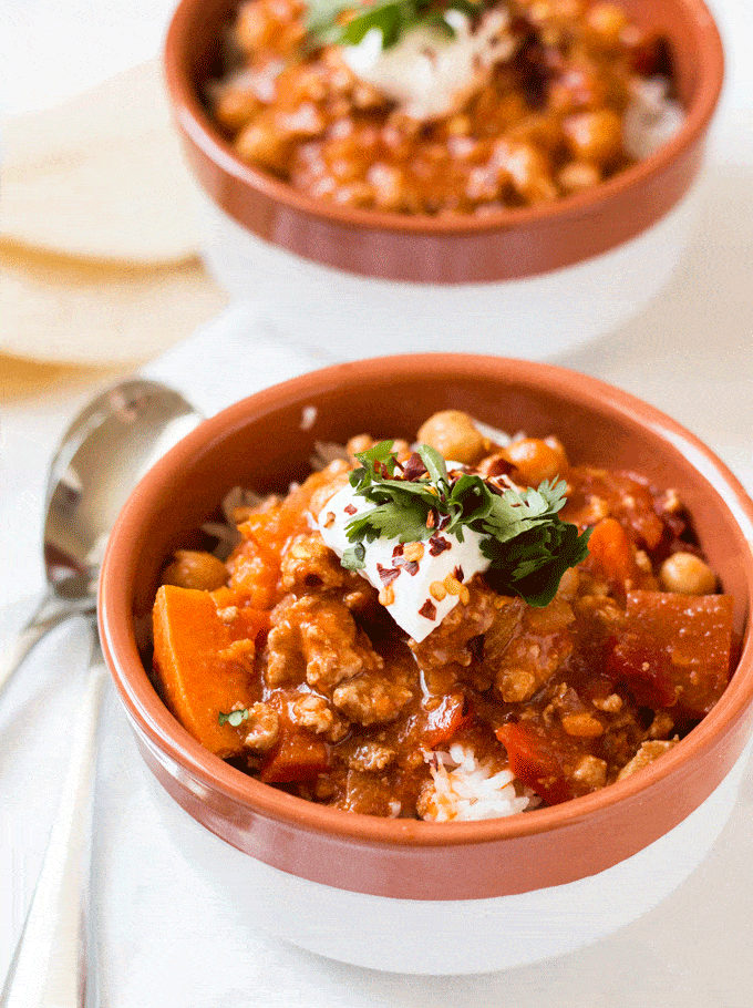 Up close shot of Turkey and Sweet Potato Chili served in white and terracotta bowls