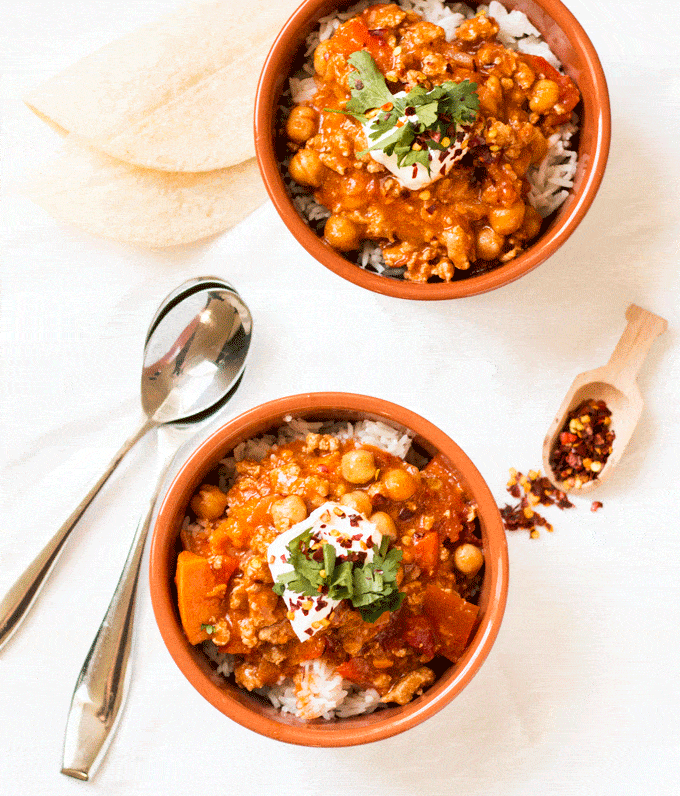 overhead shot of a chili served in a terracotta bowl and topped with sour cream and cilantro