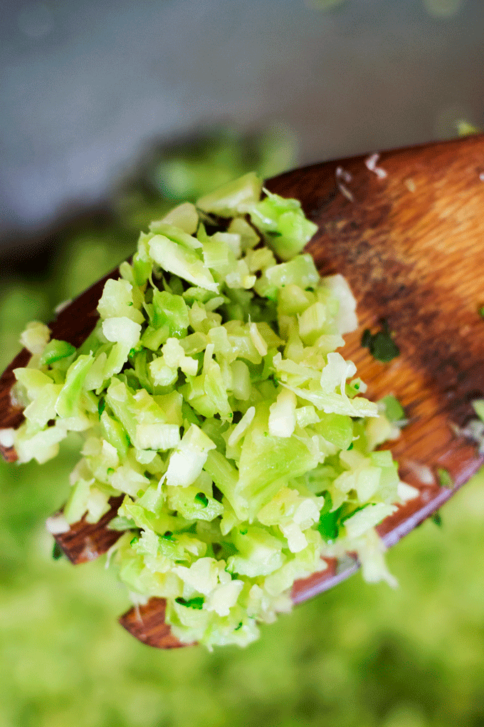 a wooden spoon holding some broccoli rice