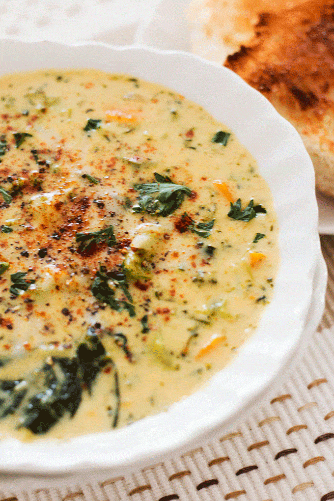 Instant Pot Broccoli Cheese Soup in a white bowl with lots of toppings