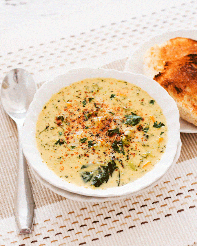 Instant Pot Broccoli Cheese Soup in a white bowl with a side of bread