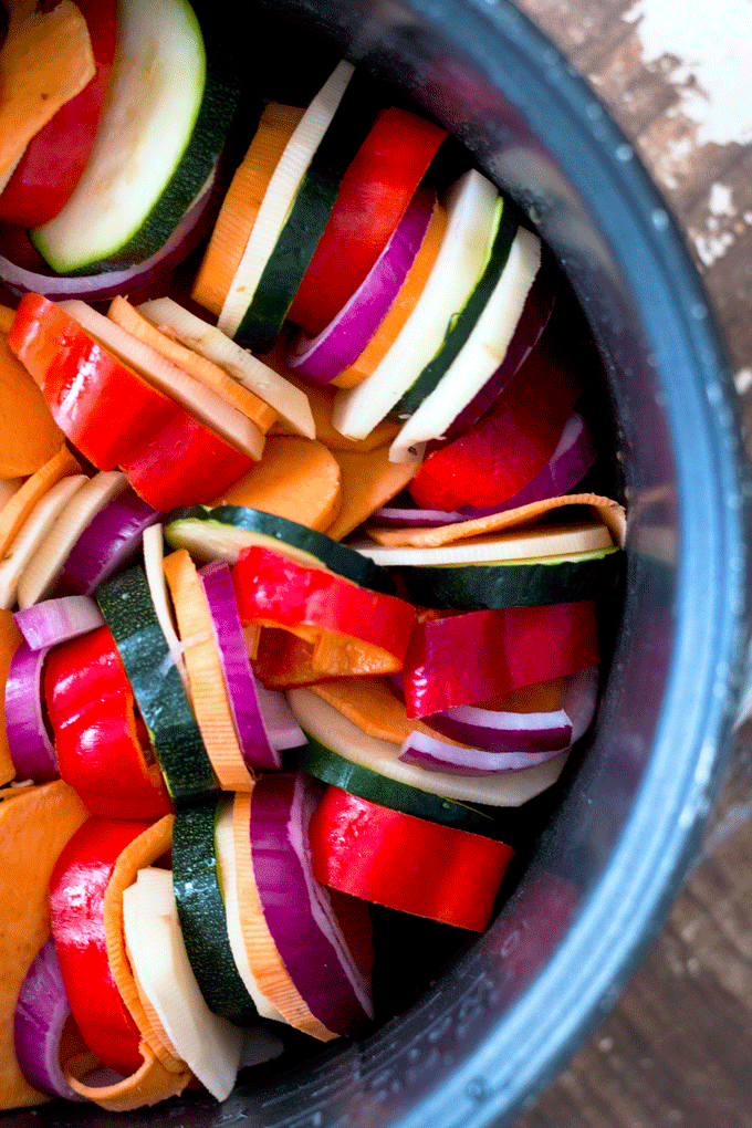An overhead shot of slow cooker ratatouille vegetables arranged in the bowl of a slow cooker in a spiral 
