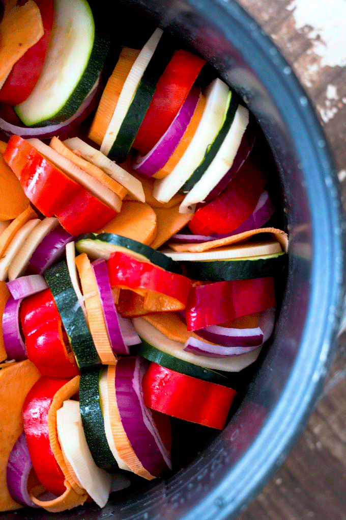 An overhead shot of slow cooker ratatouille vegetables arranged in the bowl of a slow cooker in a spiral