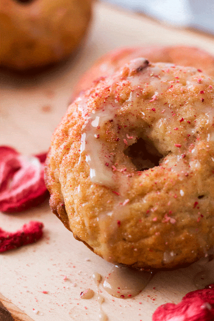 Up close shot of a baked donut with glaze and strawberry powder