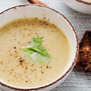 single bowl of cream of celery soup with celery leaf for decoration