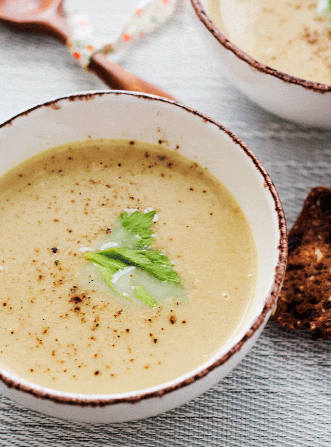 single bowl of cream of celery soup with celery leaf for decoration. 6 Ingredient healthy celery soup