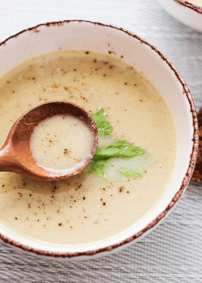 bowl of cream of celery soup with wooden spoon full of soup in bowl. 6 Ingredient healthy celery soup