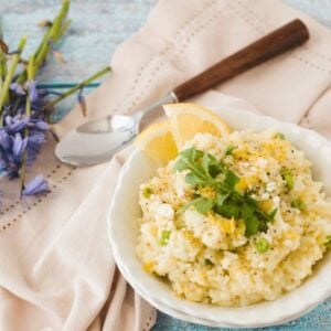 pea and asparagus pressure cooker risotto in white bowls with bluebells in the background