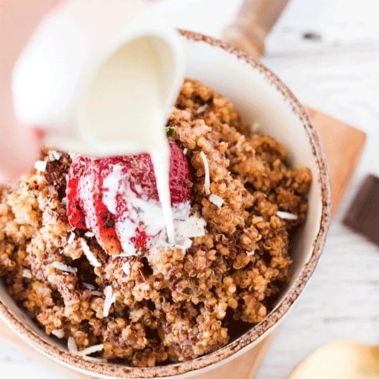 Instant pot breakfast: chocolate covered strawberry quinoa breakfast in an off white bowl with milk being poured on top