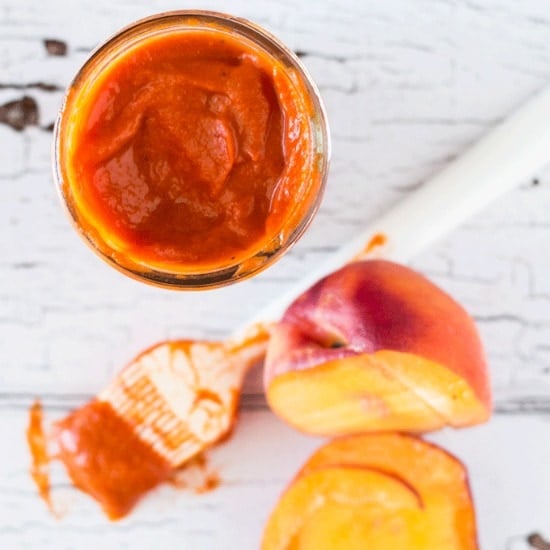 Peach BBQ Sauce in a mason jar with a basting brush beside it
