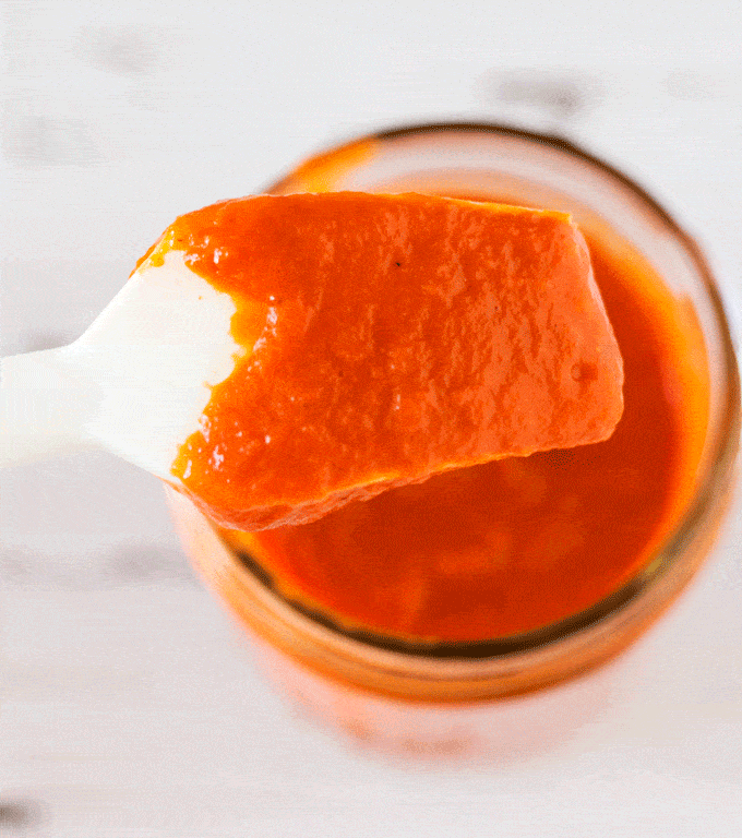 Up close shot of Naturally Sweetened Fresh Peach BBQ Sauce on a basting brush
