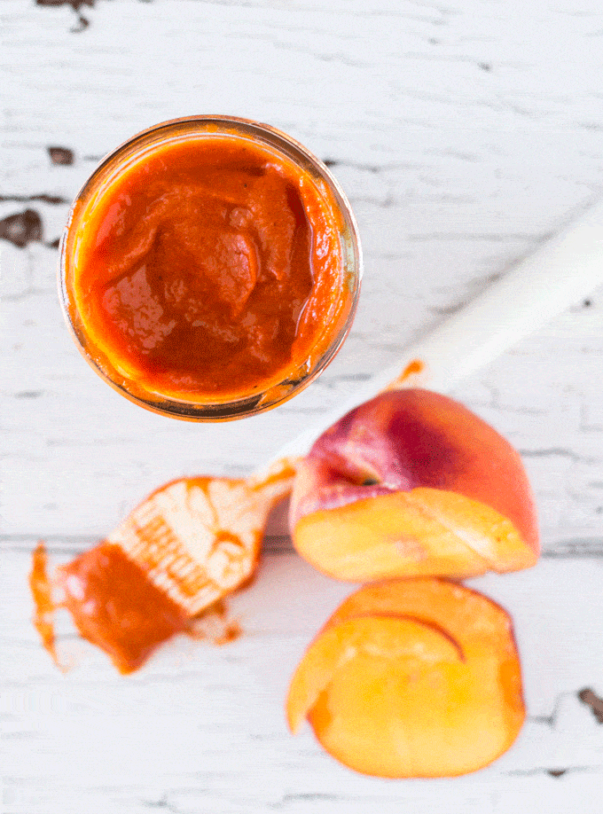 Naturally Sweetened Fresh Peach BBQ Sauce in a mason jar with a basting brush covered in sauce