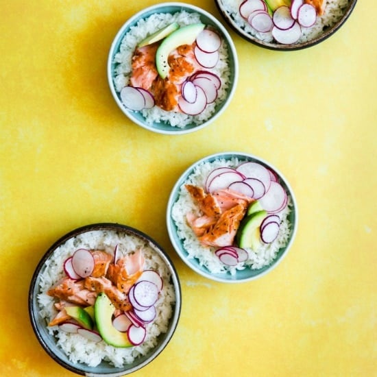 teriyaki salmon rice bowl on a yellow background