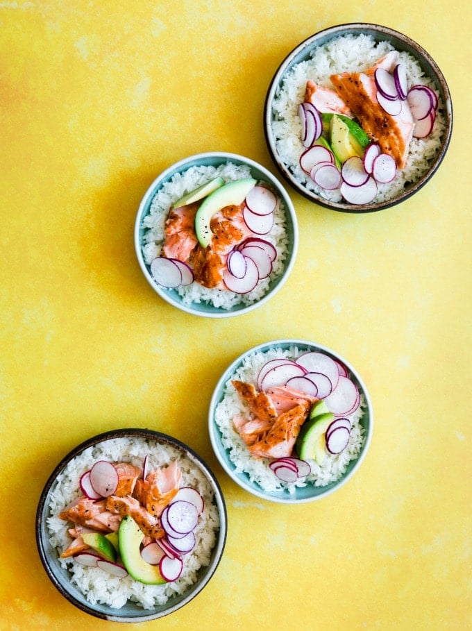 teriyaki salmon rice bowl on a yellow background