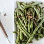 Garlic pepper skillet beans on a white dish topped with crispy garlic