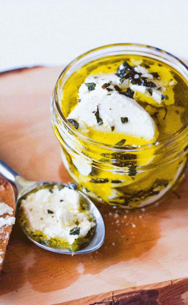 Wooden board with Marinated Goat Cheese Log with Fresh Garden Herbs