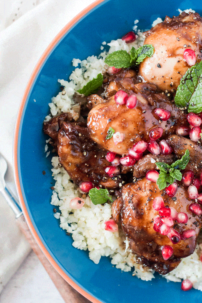 Overhead shot of Honey Pomegranate Balsamic Glazed Chicken Thighs displayed on top of a bed of cauliflower rice