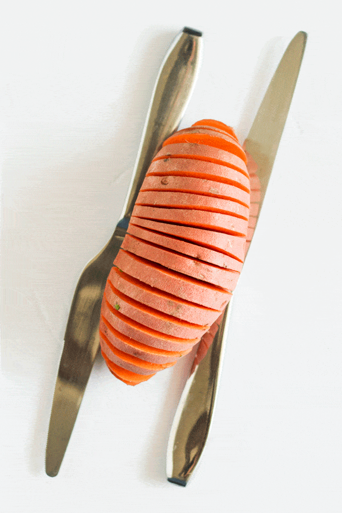 Cutting method for Parmesan and Sage Hasselback Sweet Potatoes: sweet potato in between two knives