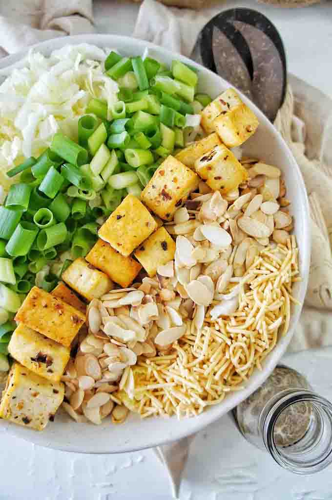 All of the ingredients for Crispy Tofu Crunchy Noodle Salad in a white bowl