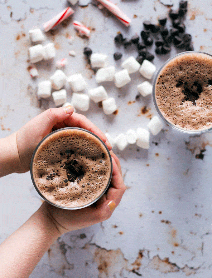 hands holding The Best Hot Chocolate Recipe Using Real Chocolate in a glass cup
