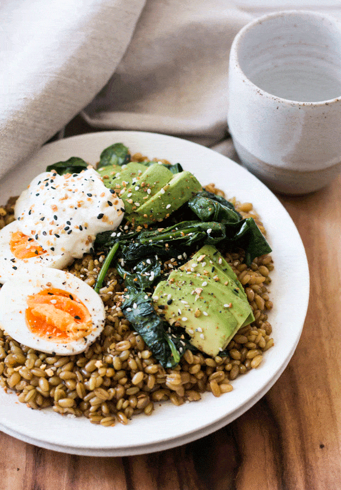 flat lay shot of Cumin Spiced Farro Breakfast Bowl Recipe on a white plate with wooden background