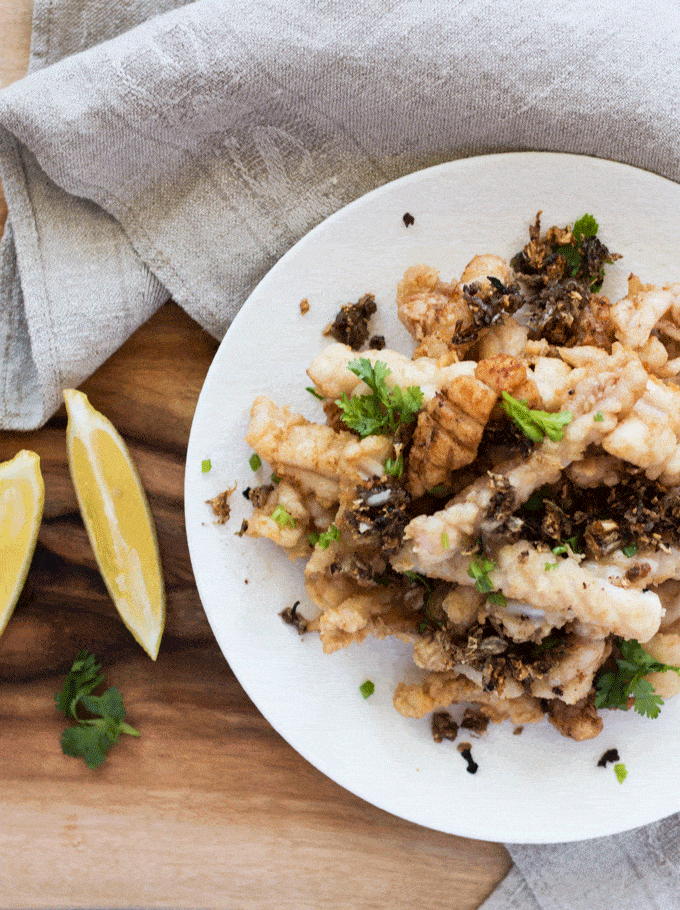 flat lay of Salt and Pepper Squid on a white plate sprinkled with chopped cilantro