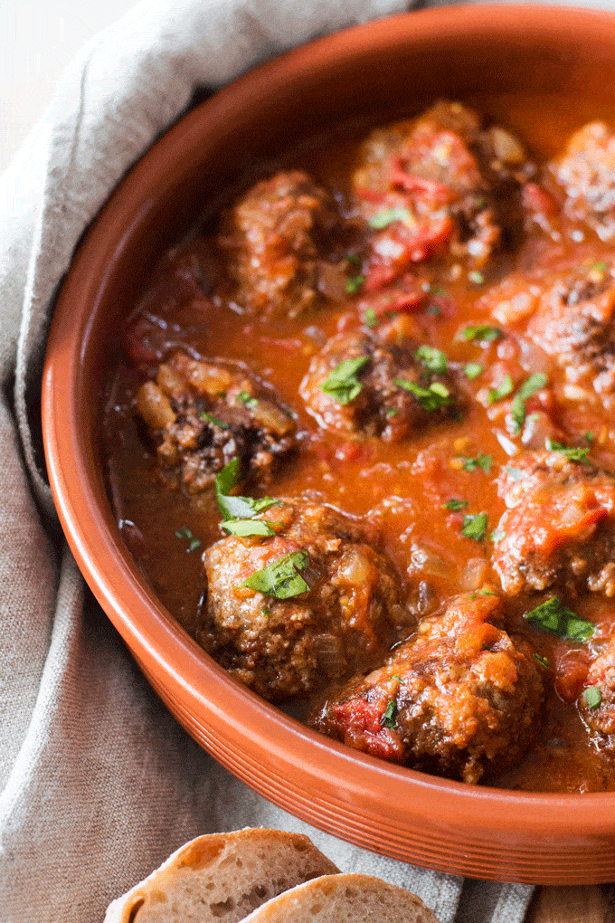 A close up shot of A Smokey Spanish Meatballs in a terracotta bowl
