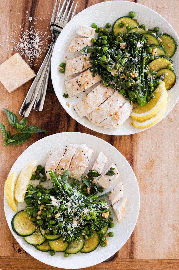 plated One Pan Lemon Parmesan Chicken with Garlic Butter Veggies on a wooden board