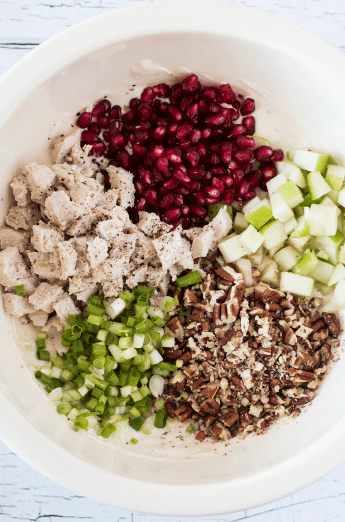 all of the ingredients for pomegranate chicken salad in a white bowl
