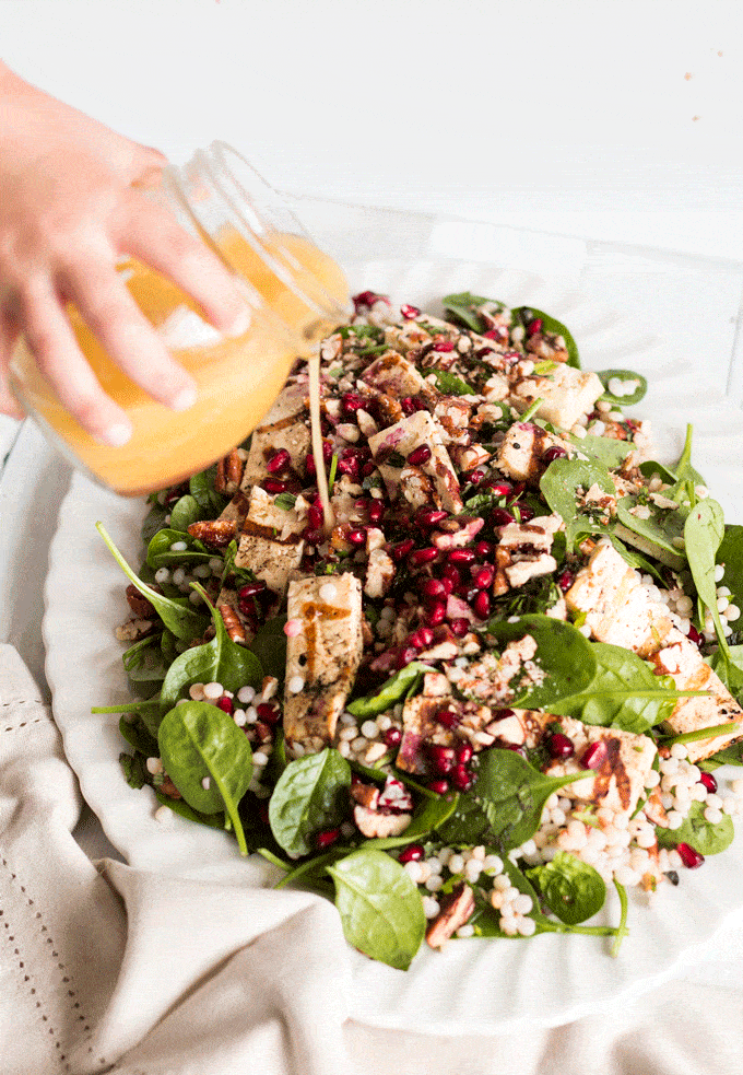 Halloumi and Cous Cous Pomegranate Salad Recipe with dressing being poured over