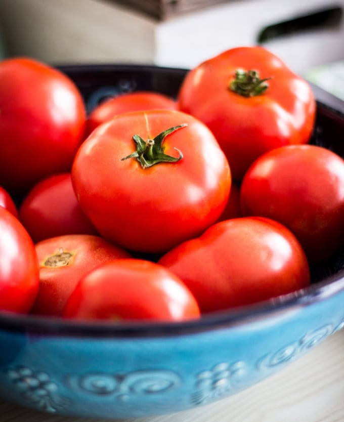 A bowl of fresh tomatoes for Eating plant based on a budget